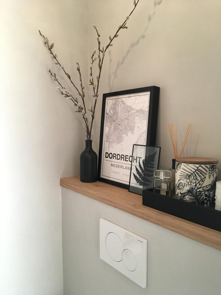 Exclusieve badkamerrenovatie met beton ciré in Amstelveen trak ingebouwde eikenhouten nis met luxe accessoires boven een wit greeploos bedieningspaneel in Amstelveen